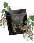 A black packet labeled "Lapsang Souchong Season Salt," featuring smoky black tea seasoning and Lapsang Souchong tea, is surrounded by illustrations of green plants, mushrooms, and herbs. Gold "MAGIC HOUR" text decorates the top.