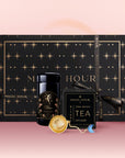 The Libra Astrology Tea Gift Set features a black and gold star-patterned "Magic Hour" box with a tea jar, Opal Moon Ritual Tea floral blend, and gold infuser—all on a pink background. Ideal for astrology lovers.