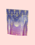 A vibrant stand-up pouch featuring a decorative geometric design in shades of blue, purple, and gold. The bag is elegantly labeled "Blue Beauty Tea Boost" in a stylish font, giving it a luxurious appearance.