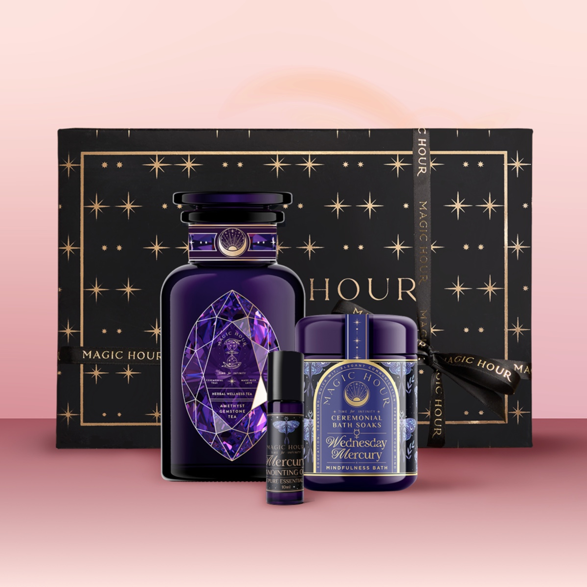 The Mercury Bath & Beauty Box includes a black and purple gem-shaped bottle, aromatherapy bath items, a mini spray vial, gemstone-infused tea, all branded "Magic Hour" in a black and gold gift box.