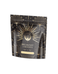 A black and gold pouch labeled "Metabolism Balance: Breakfast with Benefits" features bold black tea and metabolism-boosting spices. Intricate gold lotus and sunburst patterns adorn it. The resealable top highlights that it is organic, vegan, and non-GMO.