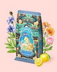 A vibrant package of Nuwa Goddess of Creation Tea for Intuition: Dragon Yuzu Oolong, adorned with ornate designs and a meditative figure amid flowers and lemons on a soft pink background, captures the tranquil spirit of Japanese yuzu tea.