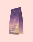 A purple and gold package of Pitta: Caffeine-Free Saffron Tea for Balancing Body, Mind & Emotions features a meditating figure, starry sky, crescent moon, and geometric patterns—ideal for a calming herbal ritual.