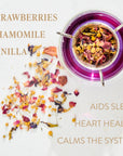 A glass cup of Magic Hour's Queen of Ukraine: Spring Blossom Tea sits on a white surface. The tea, a mix of dried strawberries, chamomile, and vanilla flowers, has some scattered around the cup. Text on the image lists ingredients and benefits: "Aids Sleep," "Heart Health," and "Calms the System." Experience the magic hour with every sip.