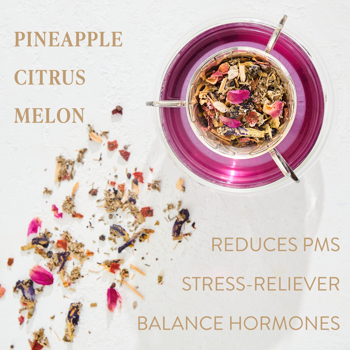 A cup of Queen of Wellness: Women's Hormone Balancing Tea Refill Pouch with scattered loose tea leaves on a white surface. The text "PINEAPPLE, CITRUS, MELON" is on the left, while "REDUCES PMS, STRESS-RELIEVER, BALANCE HORMONES" is on the right. Made with organic herbs for women's reproductive wellness, the light brown tea contains various dried herbs and flowers.