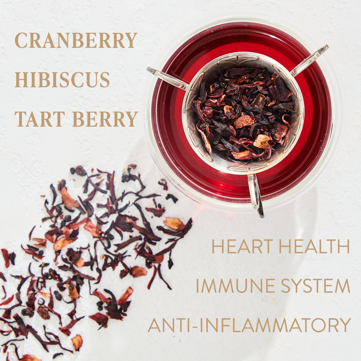 A top view of a cup filled with red tea and garnished with dried hibiscus flowers. Loose hibiscus petals are scattered on the white surface beside the cup. The text reads: "Ruby Moon™ Herbal Tea Refill Pouch. Heart Health, Immune System, Anti-Inflammatory". A caffeine-free healing potion packed with vitamin C.