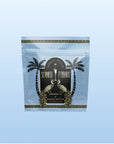 A silver packet labeled "Summer Fridays™: French 75" features two gold peacocks and palm trees, with "White Tea" made from Silver Needle white tea written below, set against a light blue background.