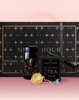 The Taurus Astrology Tea Gift Set features a black and gold star-patterned "Magic Hour" box, a luxury tea jar, Opal Moon Ritual astrology tea, and a gold tea infuser, arranged before a pink gradient background.