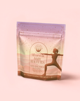 A pastel tea package features a woman in a yoga pose amid soft mountains and stars. The label reads “Vata: Caffeine-Free Saffron-Rose Spice Tea”—an herbal Ayurvedic blend for calming the mind and supporting inner balance.