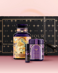 The Venus Bath & Beauty Box is a luxury self-care gift set with a decorative bottle, jar, and small tube adorned in purple and gold, beautifully arranged before a black and gold star-patterned box on a pink backdrop.