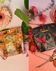 Two elegantly crafted tea packages are adorned with a variety of flowers and herbs. The package on the left, labeled "Venus," flaunts an orange floral motif with butterflies, exuding sensual flavors. The package on the right, labeled "The Lovers," presents a dark starry night design—together they create the mesmerizing and beautiful "The Lovers Bundle with Venus + The Lovers Tea" by Magic Hour.