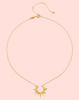 The 16" North Star Burst Necklace features an 18kt gold plate, a delicate chain, a sunburst-shaped pendant with pointed rays, an adjustable clasp, and a minimalist design.
