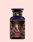 A dark purple glass bottle labeled "Monthly Magic Tea Journey Subscription" features an ornate design with a woman holding a bow and the words "She Rises, Artemis of the Wilds, Wild Moon White Tea," perfect for a goddess ritual.