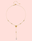 The Transformed by Love Lotus Lariat Necklace features a delicate 18k gold chain with small round accents and a single pink teardrop pendant, evoking rose quartz elegance in an exquisite lotus-inspired lariat design.