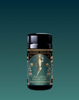 A black cylindrical tin labeled "Magic Hour" with an Art Deco design of a woman holding flowers amid floral patterns contains Hathor of Joy: Honey Nectar Herbal Tea.