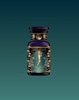 A dark glass bottle with an ornate label featuring a golden fairy and floral designs, labeled “Hathor of Joy: Honey Nectar Herbal Tea” against a gradient teal background.