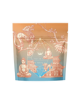 An ornate tea packaging from Magic Hour's Thai Temple Tea Case Packs, displaying a dragon, Buddha statues, a traditional Asian temple, and a geometric design with celestial elements. The artwork features an orange and blue color scheme. The text on the package reads "Probiotic-rich Pu'erh Tea, the limited tea.