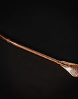 The Sips Tea Straw & Strainer Bombilla Case Packs by Alibaba are showcased against a black background. The bombilla features a straight shaft and a spoon-like filter end with small perforations, making it ideal for straining loose tea or yerba mate.