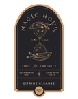 Label for Magic Hour Citrine Cleanse herbal tea features an intricate design with an hourglass adorned with cosmic elements. Prominently displayed on this gold foil front jar label are the phrases "Time for Infinity," "Ceremonial Teas," and "Made with Love.