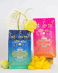 Two vibrantly colored Mercury Retro Remedy Bundle packages stand against a white background. The package on the left is blue and green, while the one on the right is pink and orange. Yellow flowers and white decorative leaves are arranged around the products, highlighting these enchanting Magic Hour blends. Save 10% when you buy the bundle!