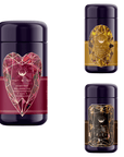 Image of three dark purple cylindrical tea canisters, each adorned with colorful gemstone designs on the labels. The left canister features the Pink Tourmaline Gemstone Wellness Tea, while the right canisters are Topaz (top) and Onyx (bottom) from the Gemstone Bundle: Pink Tourmaline, Topaz & Onyx.