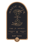 The Magic Hour Front Jar Label is an arched, stand-alone gold foil design featuring an hourglass adorned with celestial symbols and the text "Magic Hour, Time for Infinity." The label also includes "Ceremonial Teas, Made with Love" and "Ruby Moon, Herbal Tea" in gold and white on a dark background.