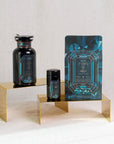 A luxurious skincare product display features an ornate glass jar, a small glass bottle, and a decorative pouch with geometric designs in blue and black. They are arranged on two gold stands against a white fabric background, evoking the elegance of Magic Hour Gemstone Bundle: Garnet, Amethyst, Aquamarine rituals.