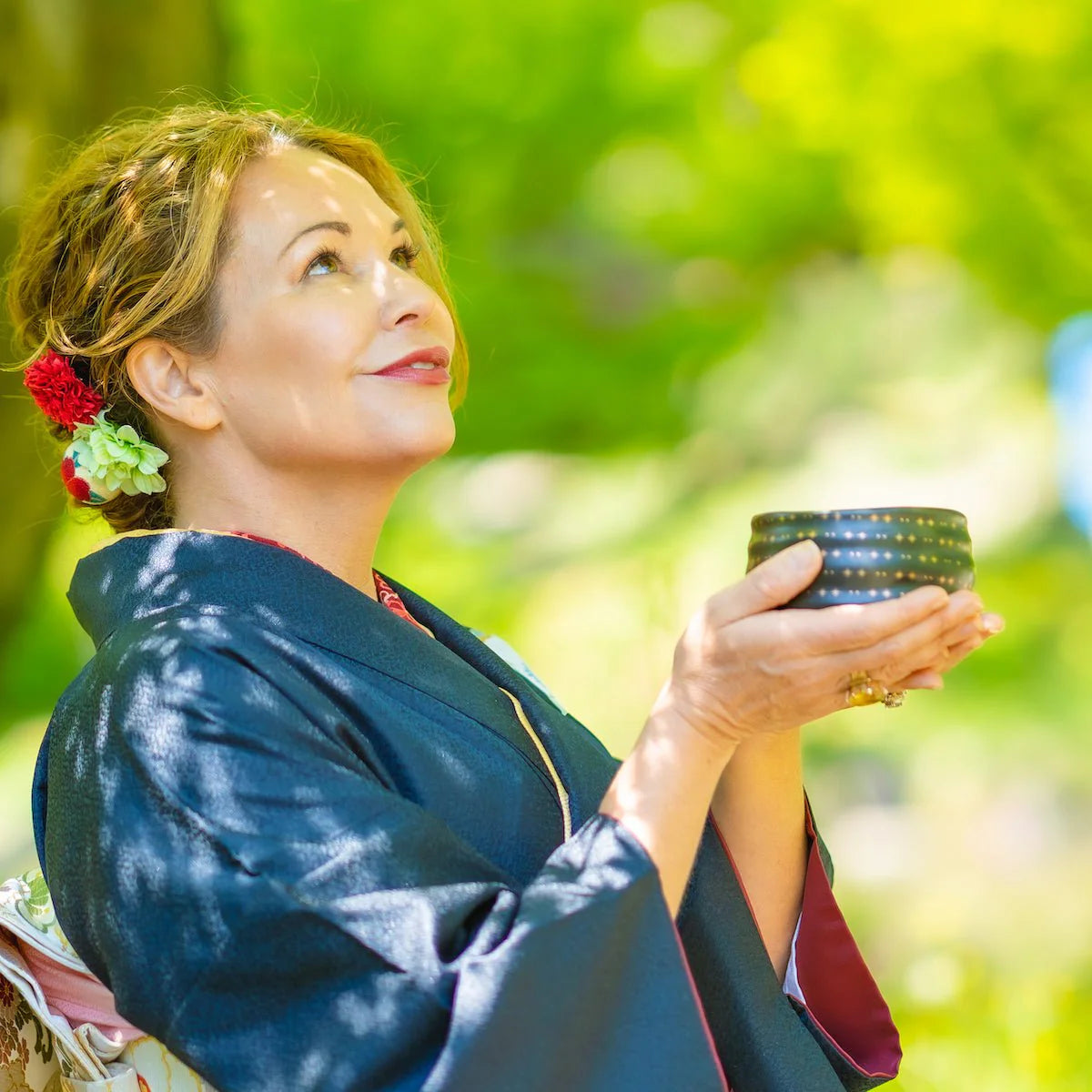 Founder of Magic Hour with glowing skin and holding ceremonial matcha bowl