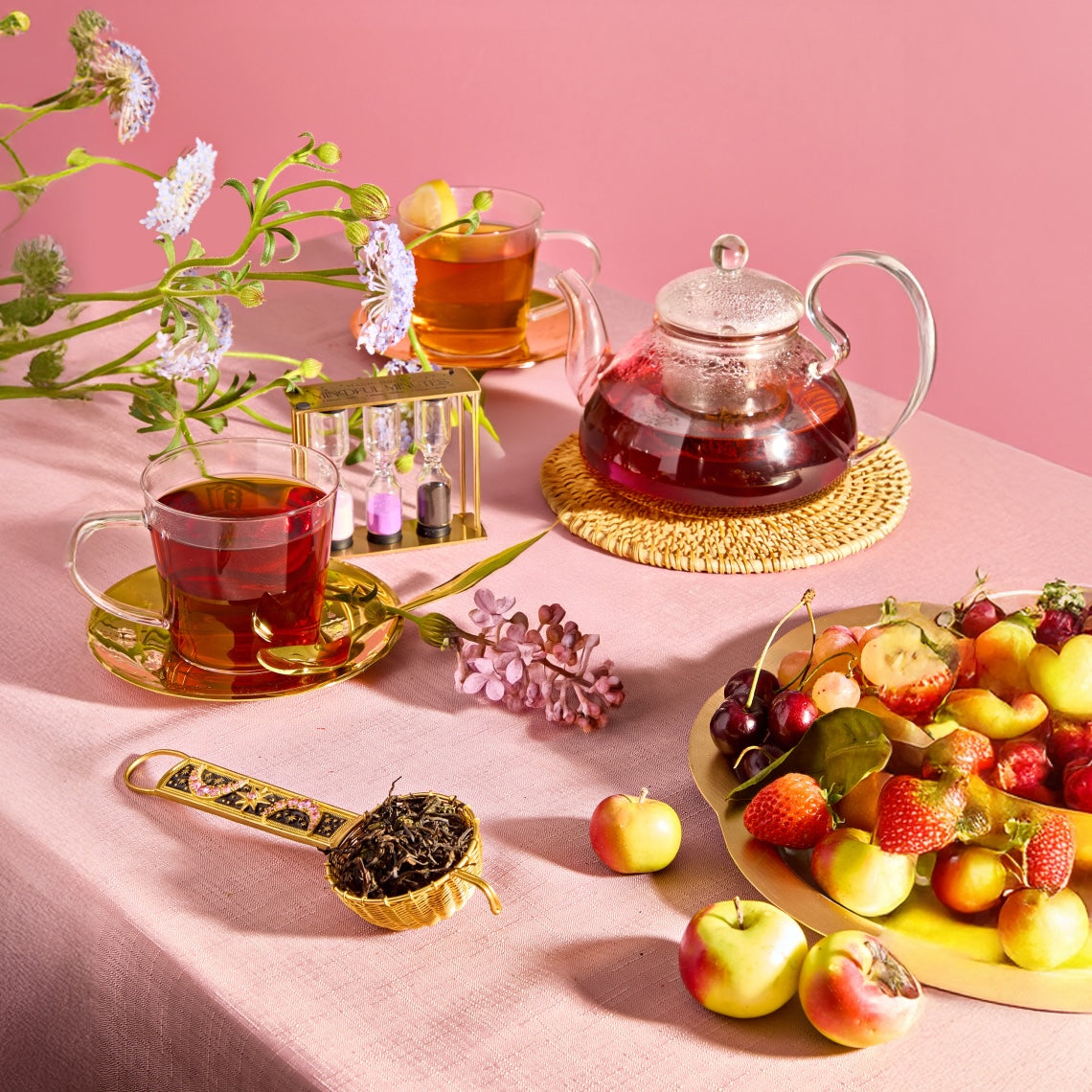 A person with dark blue nails holds a black box on a pink surface. The box says "OPEN for MAGIC" in white letters, surrounded by stars and two mystical symbols.