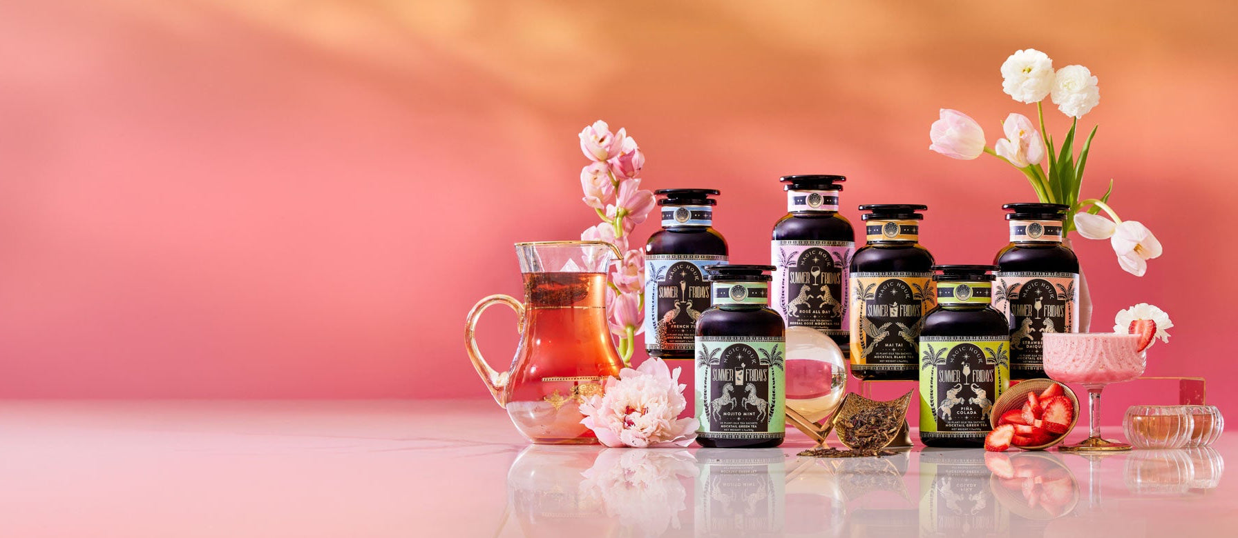 Six supplement bottles are arranged with tea, glassware, pink flowers, strawberries, and a peach gradient background, creating a fresh, elegant, and vibrant display.