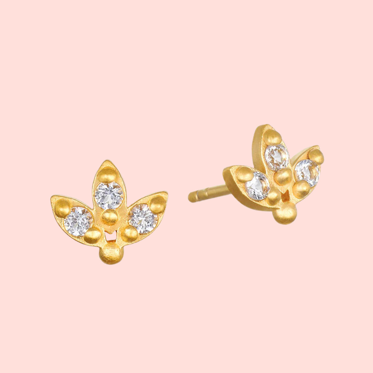 White topaz lotus studs: gold plated earrings with a three-leaf lotus design, each leaf set with a sparkling clear white topaz stone, displayed on a white background.