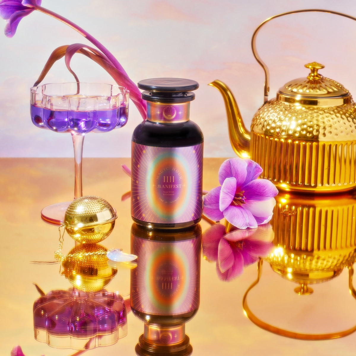 A vibrant still life composition showcases a golden teapot, a bottle labeled "1111: Seraphim's Dream Tea," a purple flower in a glass filled with purple liquid, and a tea strainer, all arranged against a reflective surface highlighted by gentle, colorful lighting.