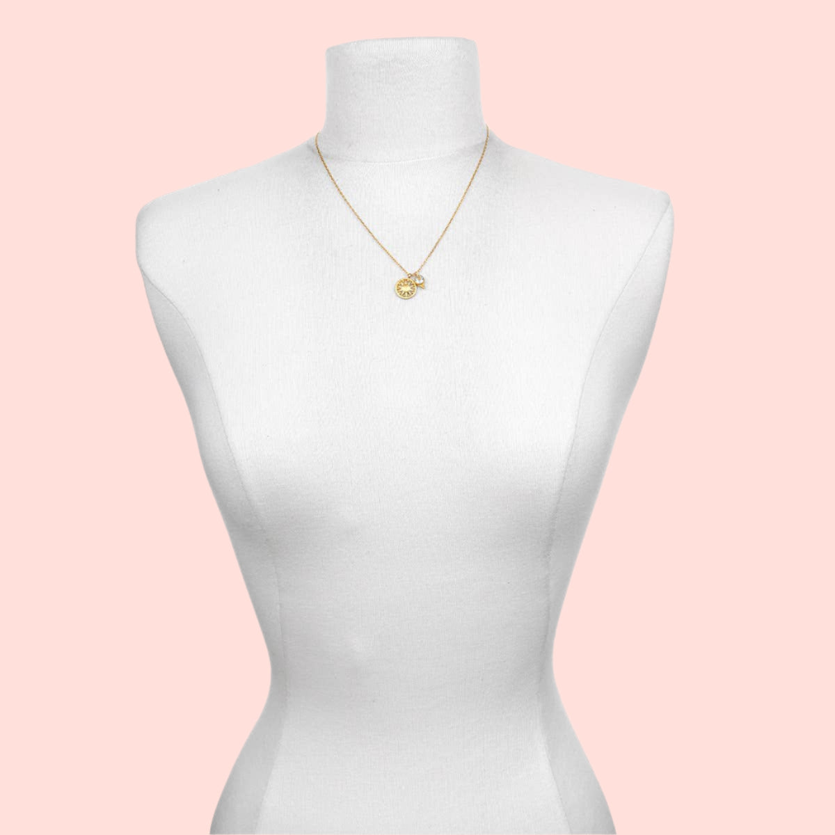 The Blue Topaz Sun Pendant Necklace is a gold-plated piece with a round blue topaz pendant, shown on a white dress form mannequin against a plain background.