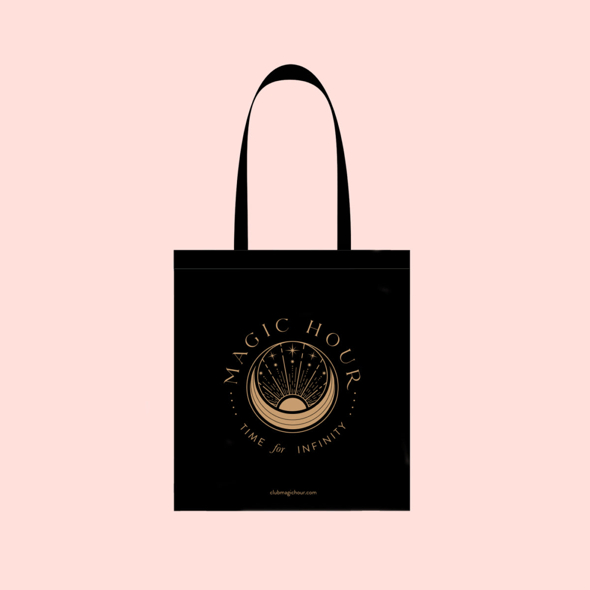 The Magic Hour Tote Bag is a black cotton tote bag featuring a metallic gold logo with a sunrise design. The words &quot;MAGIC HOUR&quot; and &quot;TIME for INFINITY&quot; gracefully encircle the emblem, set against a light peach background.