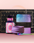 The Angel Numerology Fruit & Flower Tea Gift Set includes a black and gold box, "Angel 2222" bottle, celestial tea towel, purple starry bowl, and green-handled spoon—artfully displayed on a pink gradient background.