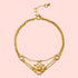 The Transformed by Love Lotus Bracelet is an 18k gold piece with a central lotus flower and a pink gemstone, flanked by two smaller pink stones and an adjustable clasp—ideal for lotus jewelry lovers.