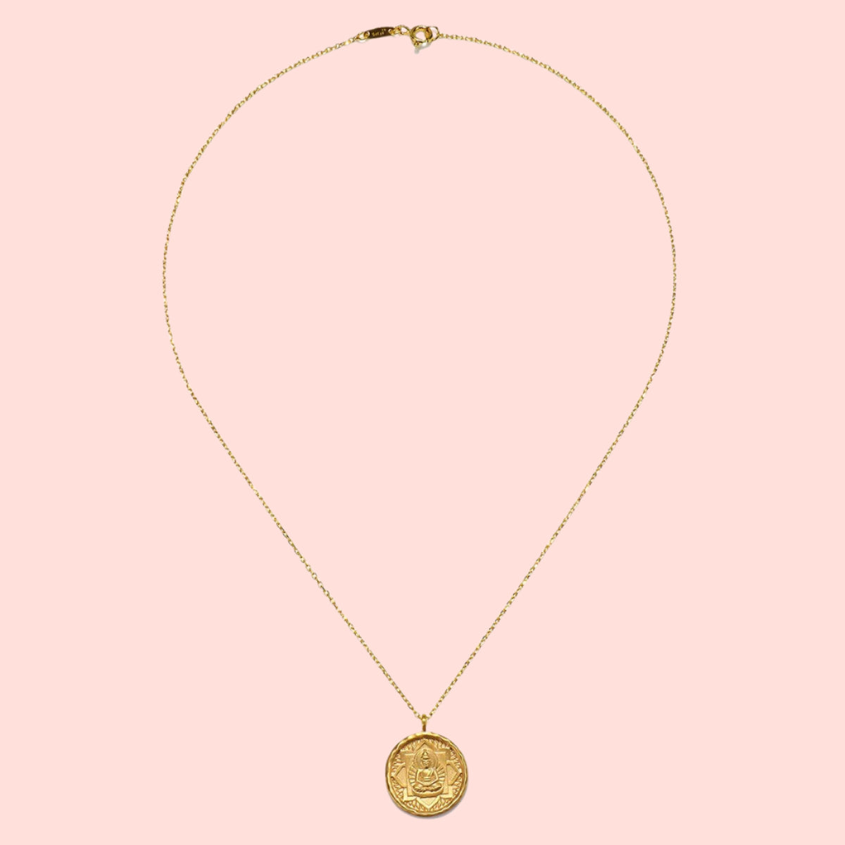 The Gold Buddha Pendant Necklace features a delicate 18kt gold-plated chain with a round, intricately engraved Buddha coin pendant, shown on a white background.