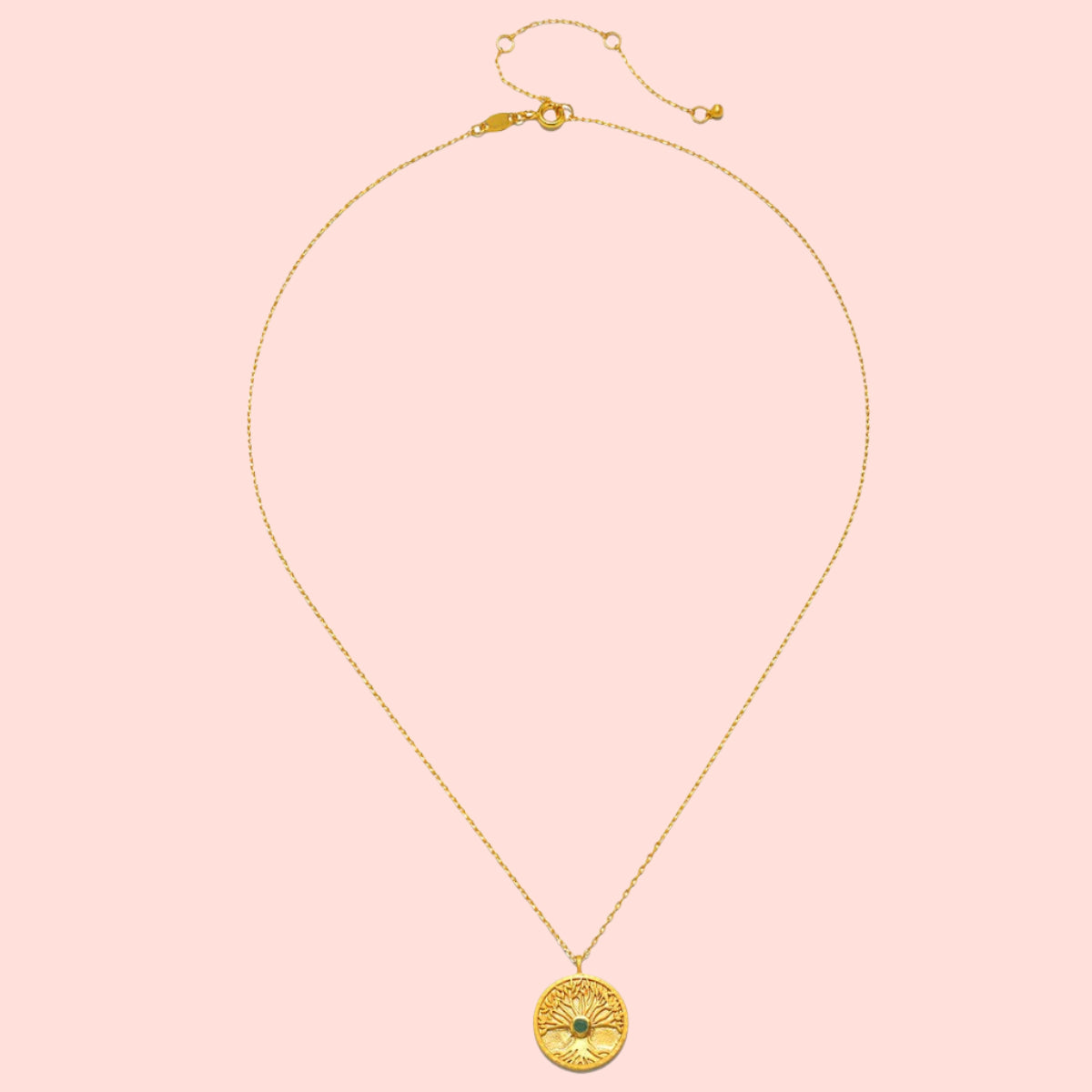The Abundant Grounding Tree Necklace features a gold chain with a round pendant engraved with a tree of life design, symbolizing grounding. Shown on a white background.