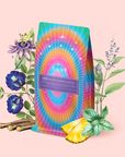 A vibrant tea package labeled "999: Adaptogenic Pineapple-Mint-Jasmine Herbal Tea" sits among illustrated herbs, flowers, licorice root, mint leaves, and pineapple on a pale pink background—blending tranquility with uplifting energy.