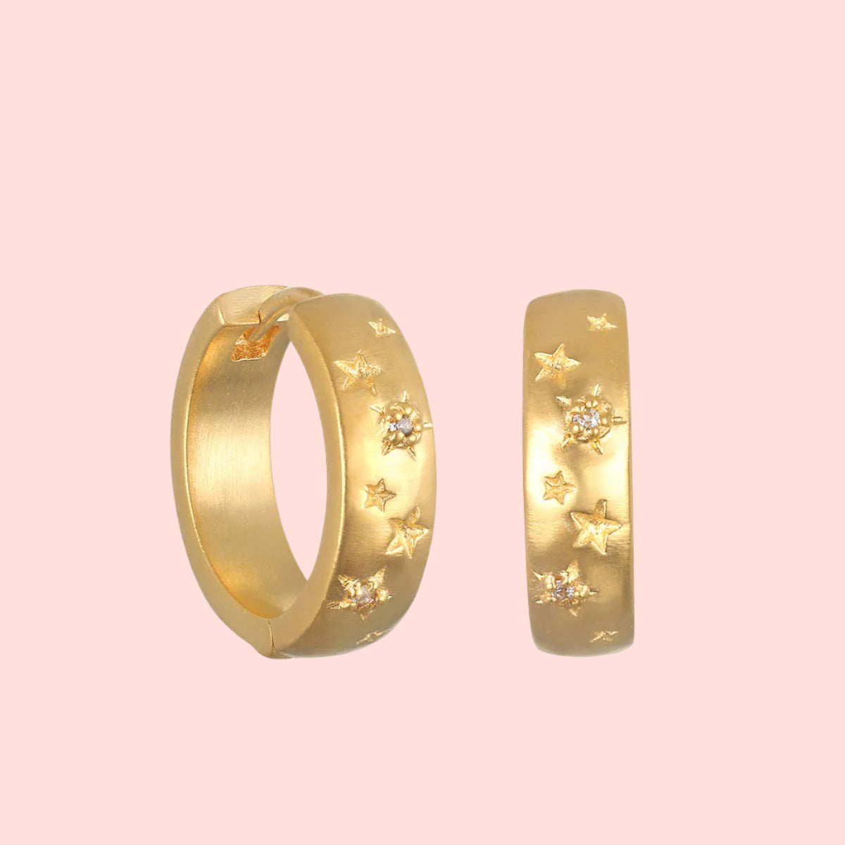 The White Topaz Gold Huggies with Stars are 18K gold plated hoops featuring engraved star shapes and sparkling white topaz stones—perfect for star jewelry lovers.
