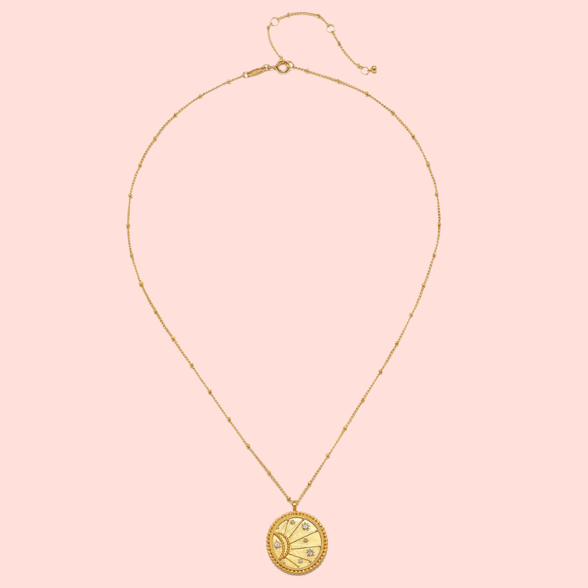 The 18" Sunburst Medallion Necklace is a gold plated piece featuring a round celestial-inspired pendant, perfect for adding charm to your look.
