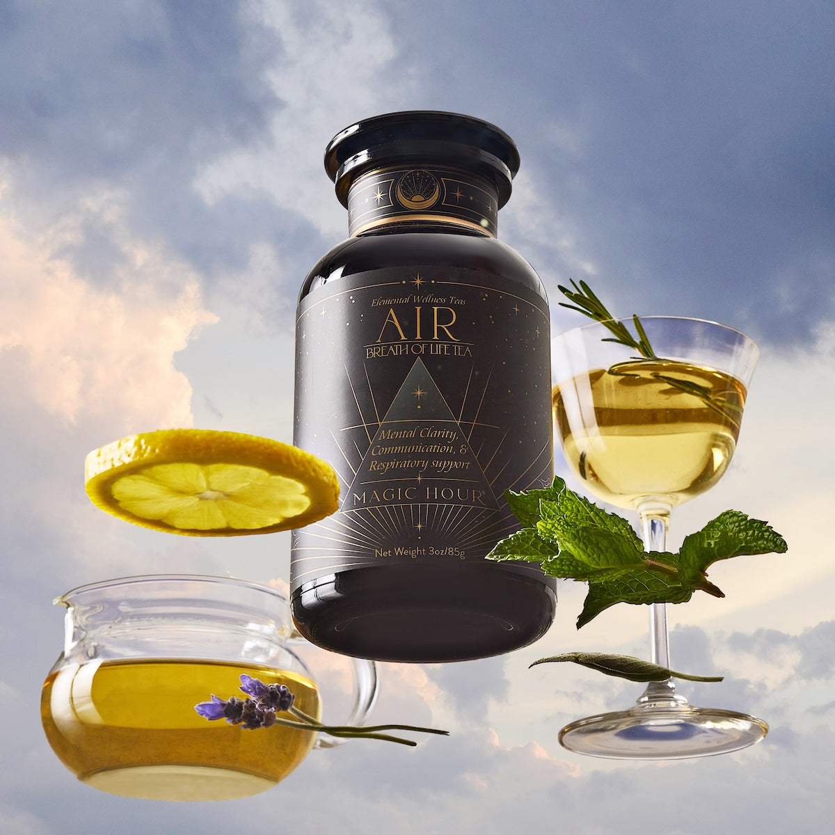 A black tea jar labeled "Air" sits among floating elements: a lemon slice, a teacup with lavender, a wine glass with tea and mint, all set against a cloudy sky background.