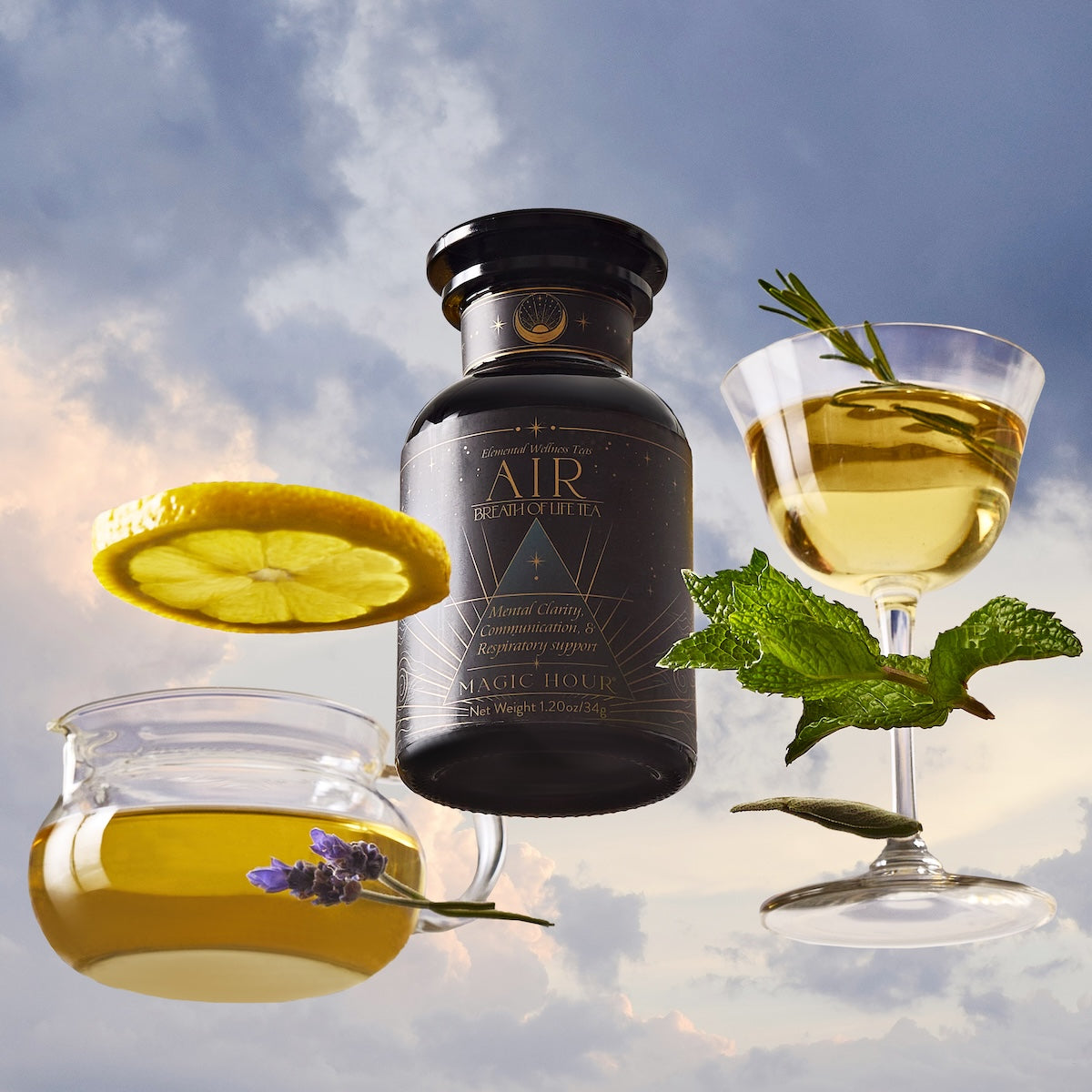 A dark glass jar of Air tea is surrounded by a glass teacup filled with yellow tea and lavender, and a coupe glass with golden tea, mint leaves, and a lemon slice, all set against a cloudy sky.