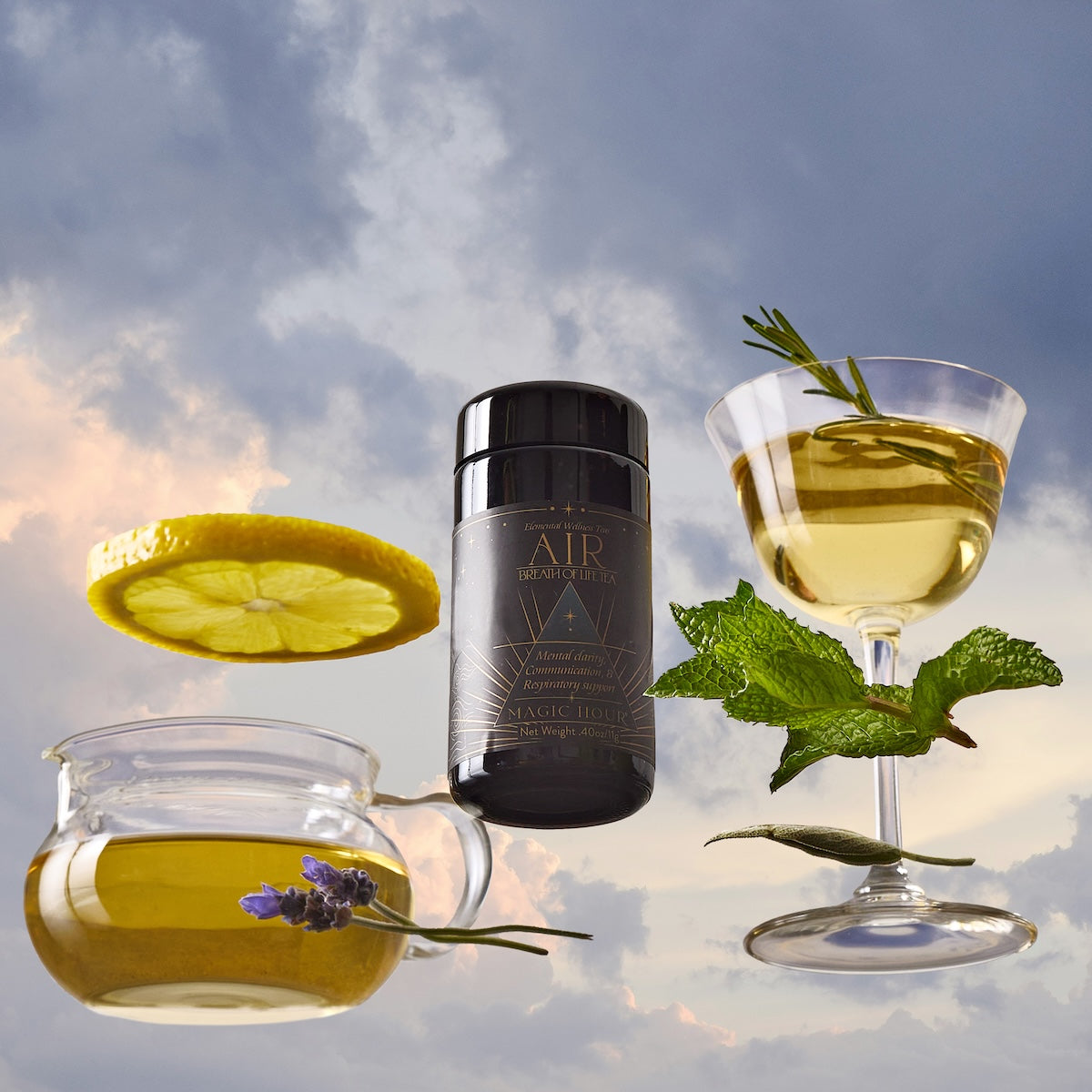 Air, a black cylindrical tea container, is placed between a glass teacup with green tea, lemon, and lavender, and a cocktail glass with tea, mint, rosemary, and lemon slice, all set against a cloudy sky background.