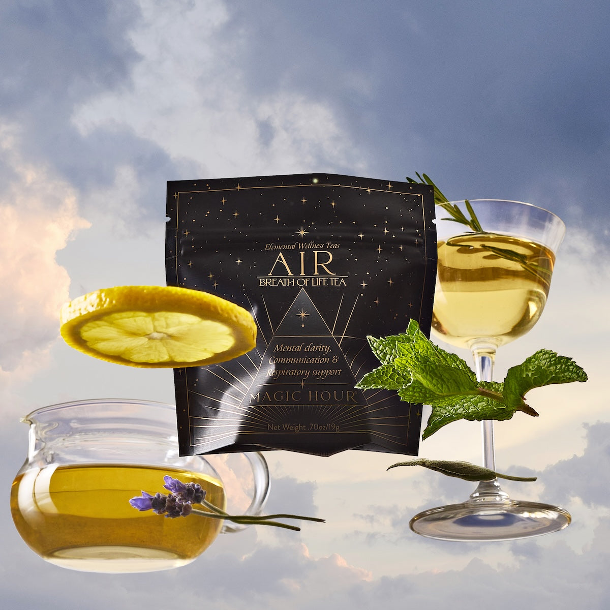 A floating tea package labeled &quot;Air&quot; is surrounded by a teacup, a coupe glass with light tea, a lemon slice, fresh mint, and lavender, all set against a cloudy sky background.