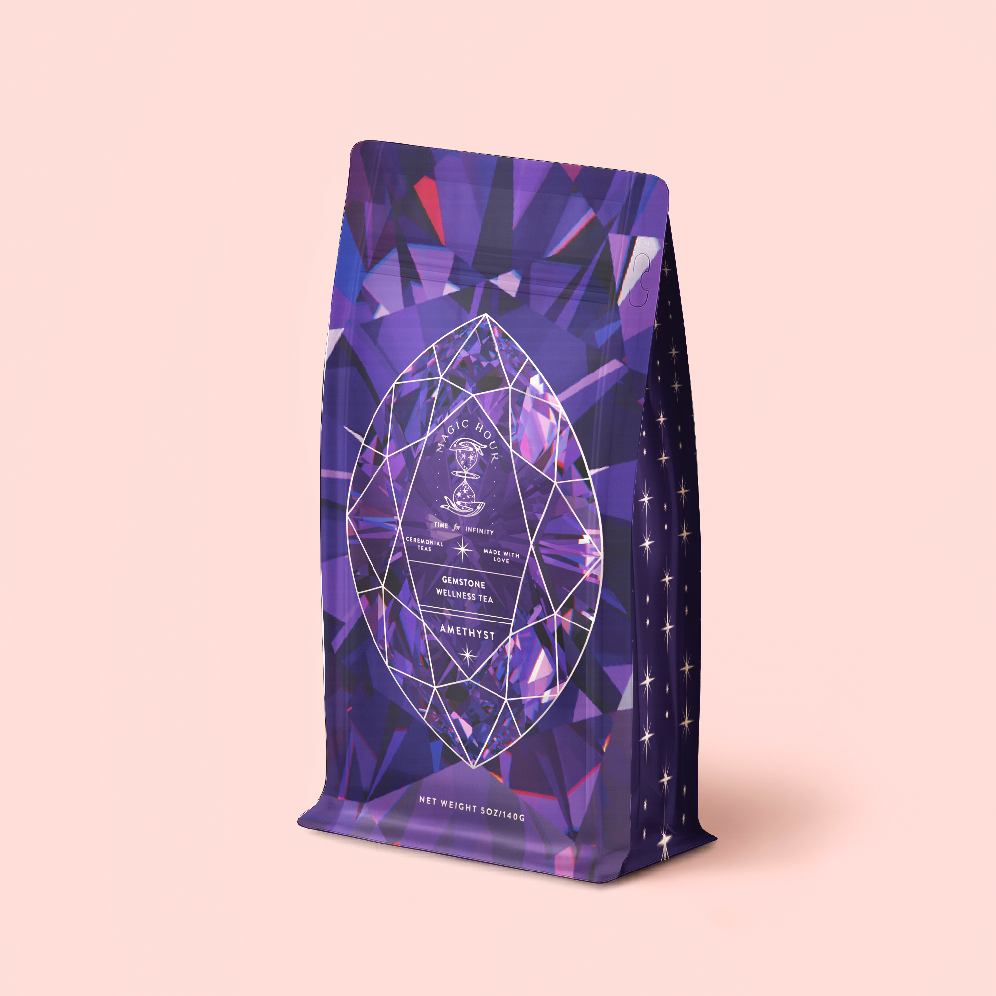 A vibrant purple refill pouch adorned with geometric, gem-inspired designs and star motifs, labeled “Amethyst: Strawberry-Passionfruit Wellness Tea,” stands upright on a pale pink background. Inspired by the calming essence of amethyst and spiritual wellness, this strawberry-passionfruit blend brings a soothing touch of tranquility to your daily ritual.