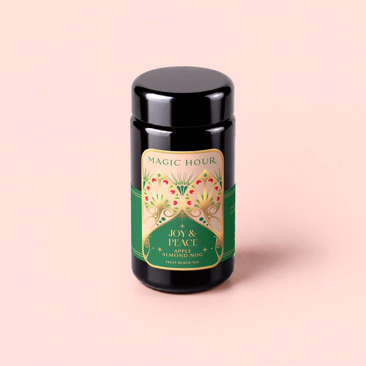 Apple Almond Nog black tea tin, adorned with an elegant green and gold label, sits against a light pink background. This festive eggnog-inspired blend combines rich black tea with organic almonds for a comforting holiday sip.