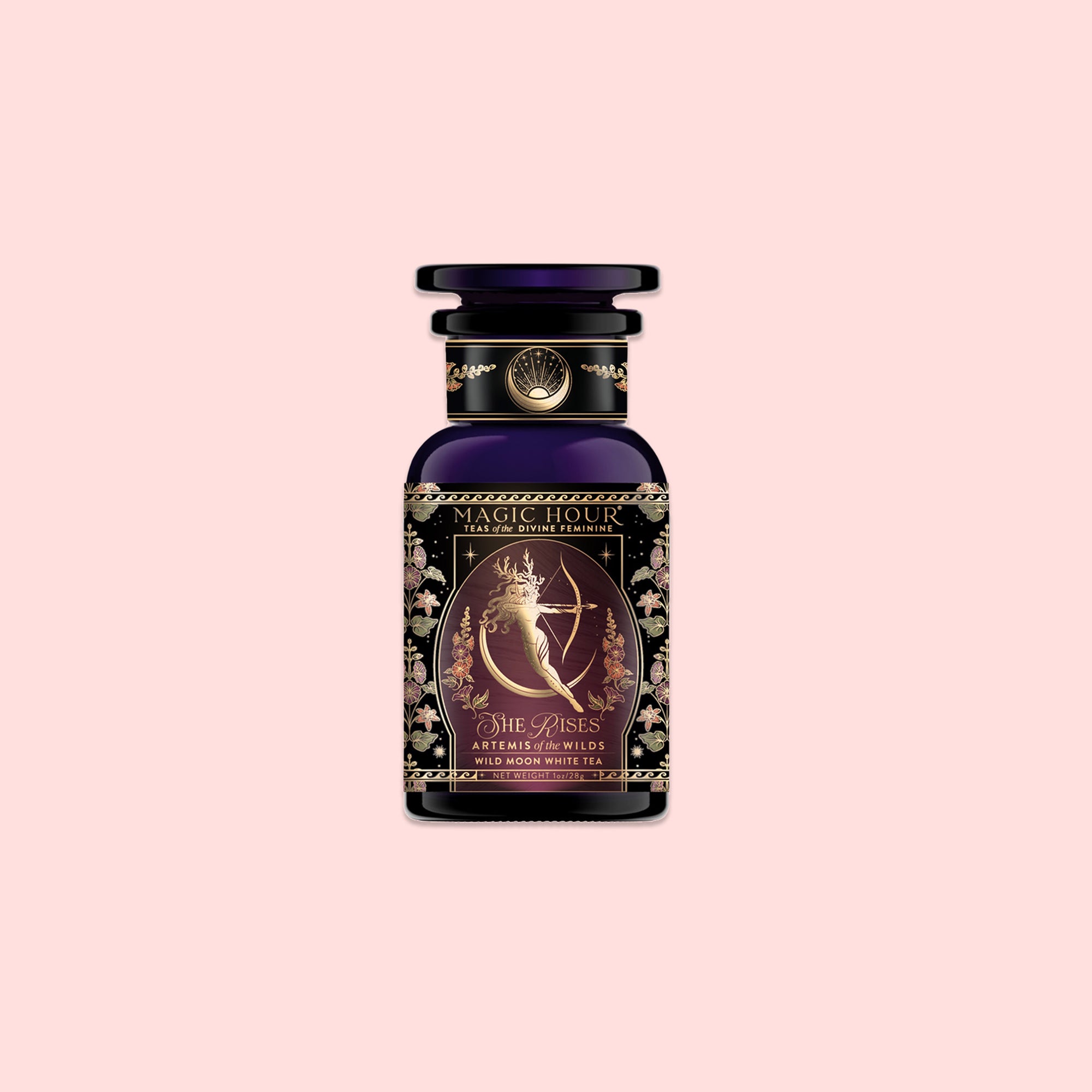 A decorative bottle of Magic Hour tea labeled "Artemis of the Wilds: Wild Moon White Tea," featuring an ornate design with a celestial figure and floral patterns on a light pink background, contains wild moon white tea for a delicate, low-caffeine tea experience.