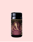 A canister of "Artemis of the Wilds: Wild Moon White Tea" by Magic Hour, adorned with a gold and purple design and featuring an illustration of Artemis drawing a bow. This low-caffeine black tea has a net weight of 1.36 oz.