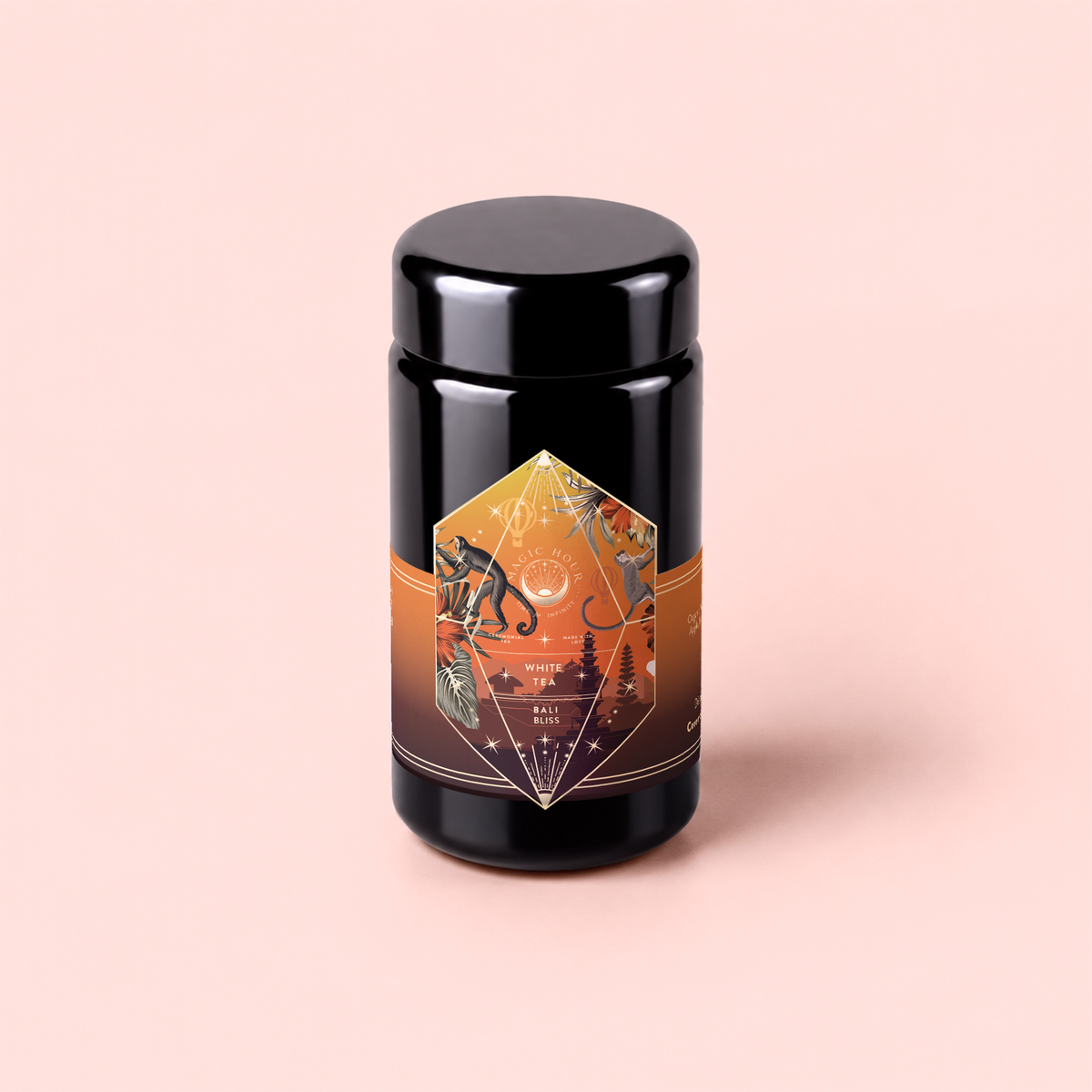 A black cylindrical container adorned with an orange, geometric label featuring abstract illustrations and text sits against a pale pink background. The design evokes the lively character of Bali Bliss: Coconut-Lime &amp; Ginger-Melon White Tea, a blend inspired by island flavors—crafted from select white teas highlighted by bright tropical notes.